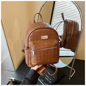 Riflesso a specchio che mostra i dettagli dello zaino in pelle intrecciata marrone con zip