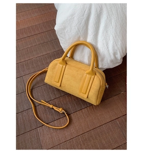 Top view of a bright yellow bowling bag on a wooden floor with white soft cushion