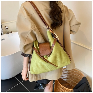 Détail du sac bandoulière vert matcha avec sangles en cuir marron et pompons en bois