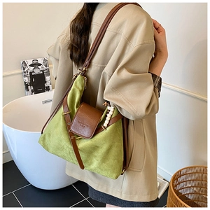 Détail du sac en daim vert avec bandoulière en cuir et accessoire pampille en perles