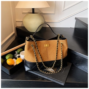 Détail d'un sac fourre-tout matelassé vintage avec fermoir doré et bandoulière chaîne