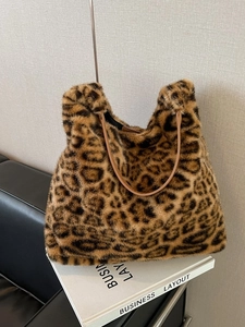 Faux fur leopard print tote bag with brown leather handles on a minimalist background