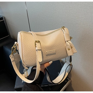 Détail du sac bandoulière en cuir grainé blanc crème avec boucles dorées et sangle large