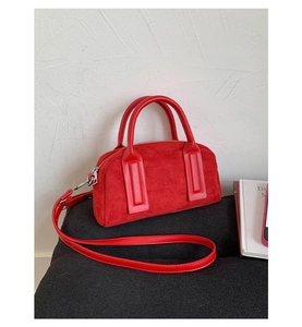 Macro detail of red suede Boston bag with silver zipper and leather top handles