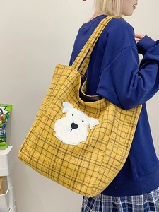 Retro yellow plaid tote bag with cute dog patch shown on shoulder in daily casual style