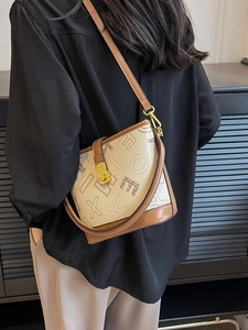 Sac seau chic crème avec détails léopard et bandoulière marron porté par mannequin