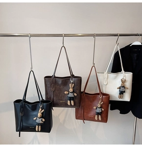 Dettaglio di quattro borse tote vintage in diversi colori con ciondoli a forma di coniglietto