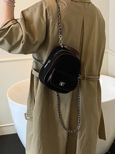Chic quilted mini backpack in black with brown trim and elegant gold chain straps