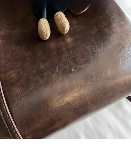 Dettaglio macro della borsa tote retrò marrone scuro in ecopelle con logo dorato