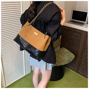 Détail du sac cabas en cuir matelassé bicolore avec bandoulière en chaîne dorée chic