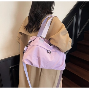 Detailed view of a light purple tote bag worn by a model in a khaki trench coat