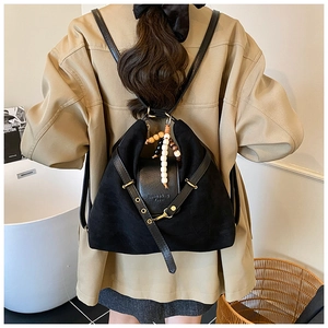 Détail du sac à dos multifonction noir mat avec pompon en perles de bois et lanière