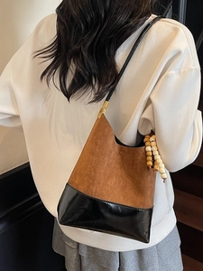 Sac seau bicolore marron et noir à texture mate avec breloque en perles de bois