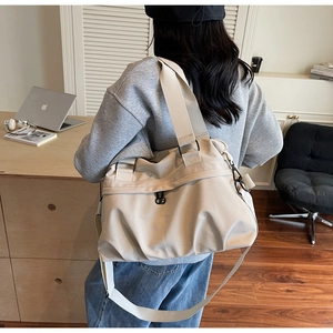 Detail of off-white nylon tote bag with wide straps and adjustable crossbody belt