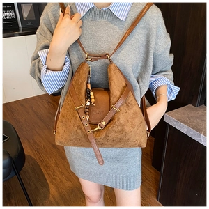 Détail du sac à dos vintage en daim marron avec perles en bois et rabat en cuir