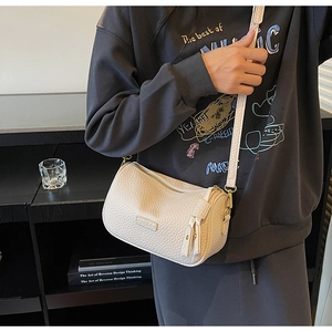 Sac bandoulière blanc en cuir grainé avec détail de franges et logo sur modèle