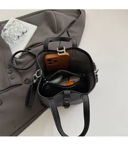 Litchi texture bucket bag detail showing internal storage and zippered liner compartment