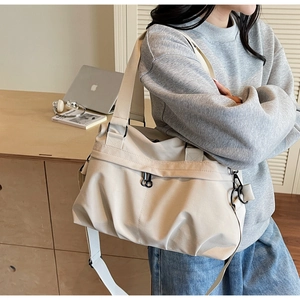 Close-up of minimalist off-white pleated canvas tote bag with wide shoulder strap