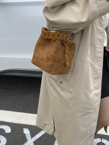 Brown frosted leather bucket bag with unique hollow ring handle and drawstring details