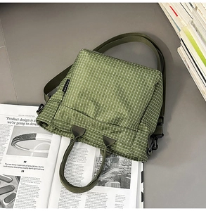 Detail of dark green checkered fabric tote bag showing textured weave and top handle