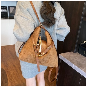 Gros plan du sac hobo en daim marron avec bandoulière en cuir et charm à perles décoratif