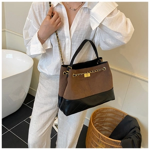 Détail du sac fourre-tout en daim marron avec chaîne dorée et motif à losanges