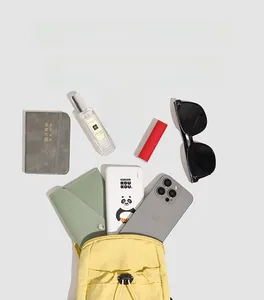 Flat lay of yellow nylon crossbody bag showing spacious interior with daily essentials