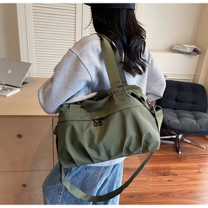 Detail showing army green canvas tote bag with wide strap and side pleats design