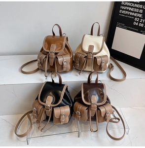 Detail view of retro mini backpacks in brown, cream, black, and coffee synthetic leather