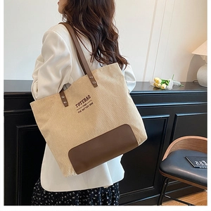 Dettaglio borsa tote in velluto a coste beige con manici in pelle marrone in stile di vita