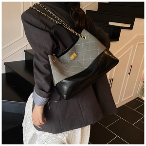 Détail de la bandoulière en chaîne et du fermoir en métal sur le sac fourre-tout