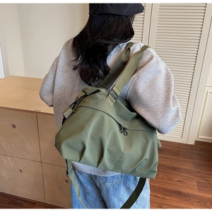 Side view of olive green large canvas tote bag with dual zippers and wide shoulder strap