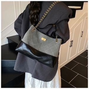 Détail du sac cabas bicolore matelassé avec bandoulière en chaîne dorée élégante