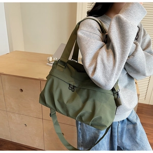 Detail of army green canvas tote with dual straps and round metal zipper ring
