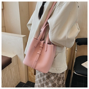 Detail of pink lychee textured leather bucket bag with top handle and shoulder strap