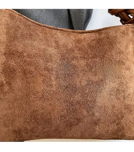 Dettaglio della morbida trama in pelle scamosciata marrone di una borsa vintage