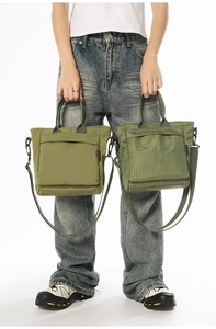Detailed close-up of utility nylon tote bags showing waterproof fabric and large zipper pockets