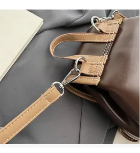 Detail of durable silver metal hooks and stitching on a vintage brown leather backpack