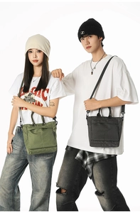 Detail of checkered canvas tote bag showing top handles and adjustable shoulder strap