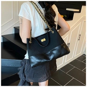 Détail du sac fourre-tout noir matelassé avec chaîne dorée et fermoir rotatif en métal