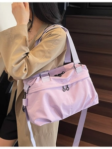 Large lavender canvas tote bag worn by a model in a trench coat on wooden stairs