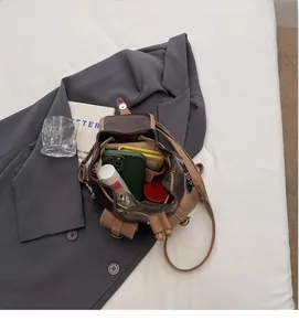 Detailed view of the interior space of the brown faux leather mini drawstring bucket bag