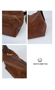 Detail view of coffee suede crossbody bag featuring sturdy zippers and cute bear charm accessory
