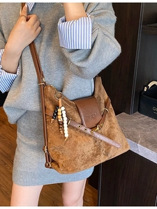 Sac à main mat marron avec pompon perlé et bandoulière réglable sur modèle