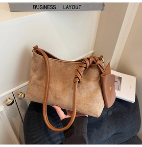Detail of brown suede shoulder bag featuring a braided knot strap and matching pouch