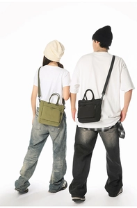 Detail showing army green and black nylon tote bags with adjustable wide shoulder straps