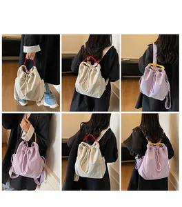 Vista dettagliata dello zaino con coulisse in beige e viola indossato da una modella