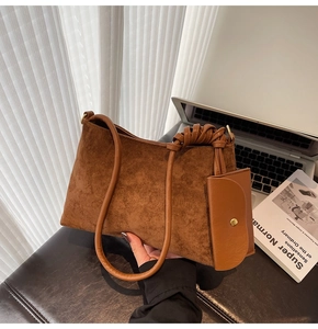 Detailed texture of dark brown suede tote bag with woven knots and matching coin pouch
