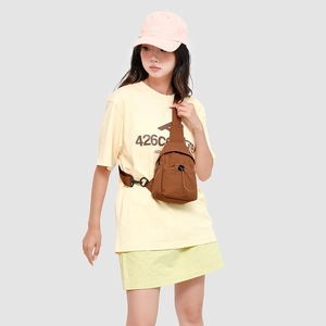 Brown nylon crossbody chest bag shown on model with front zipper and drawstring details
