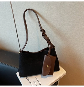 Dettaglio di un nodo in pelle intrecciata su una borsa tote in pelle scamosciata nera